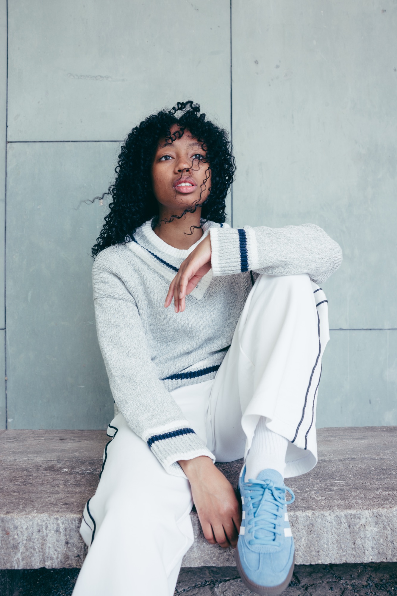 Adidas Originals Court Study – Model in hellblauem Feinstrick und weißer weiter Hose an Sichtbetonwand im Untersicht-Winkel von Kürsat Gürbüz