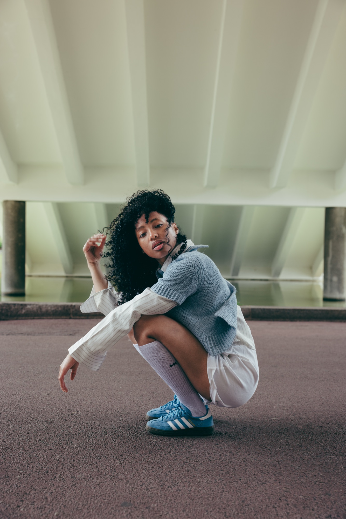 Adidas Originals Court Study – Model sitzend auf Holzpalette vor geometrischer Beton-Wabenstruktur von Kürsat Gürbüz