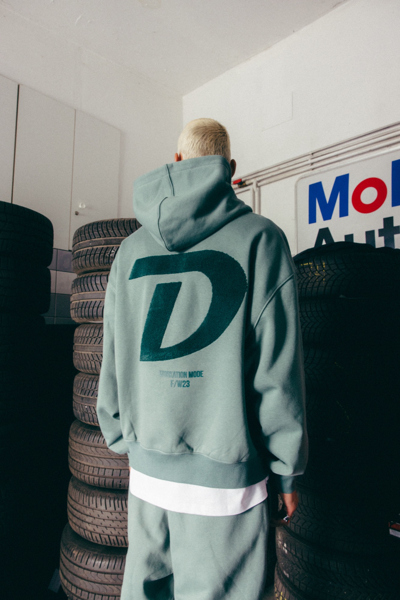 DEFSHOP – Hoodie und Workwear Rückenansicht vor Reifenstapeln