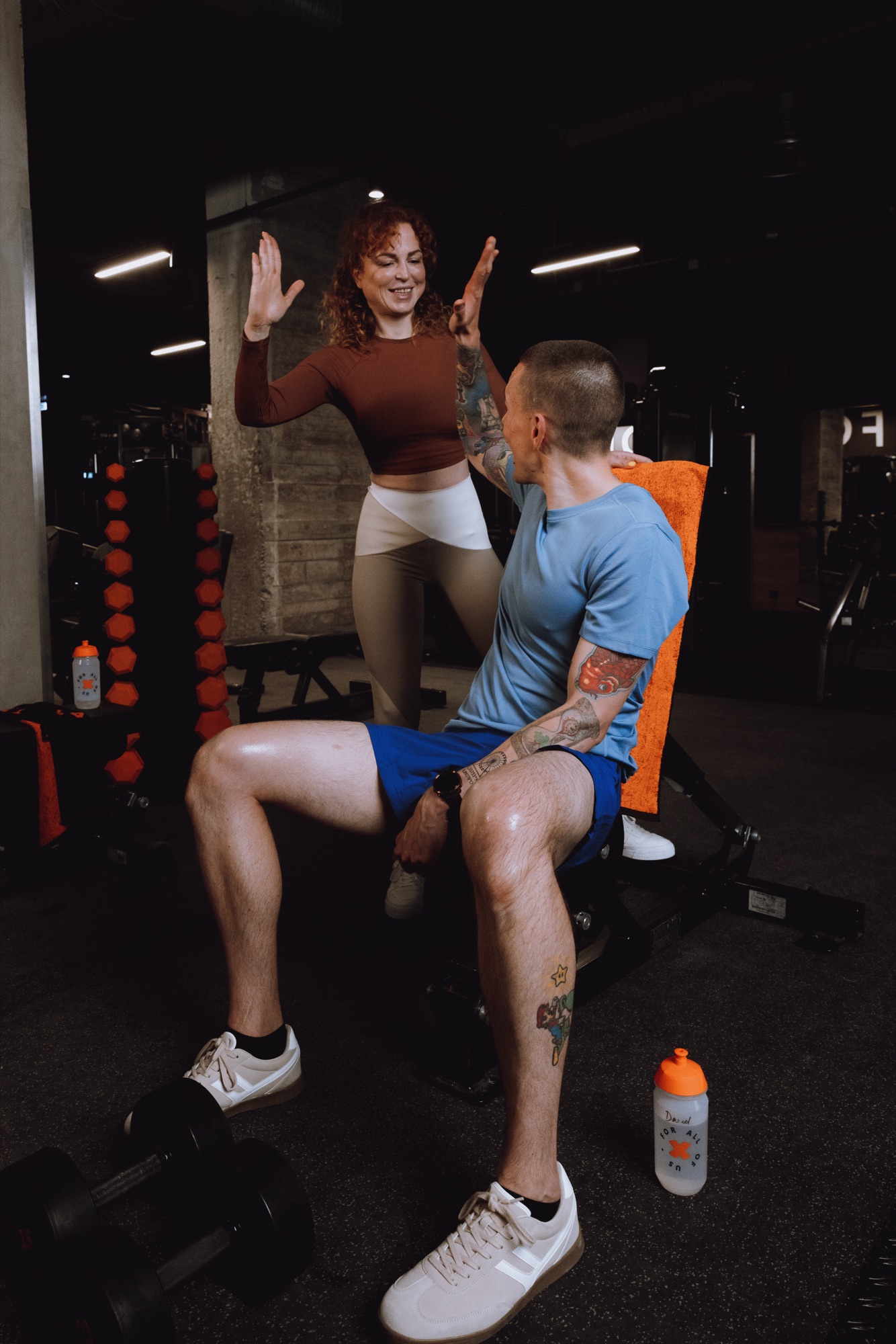 FitX – Energie und Motivation durch High-Five zweier Trainingspartner auf der Hantelbank