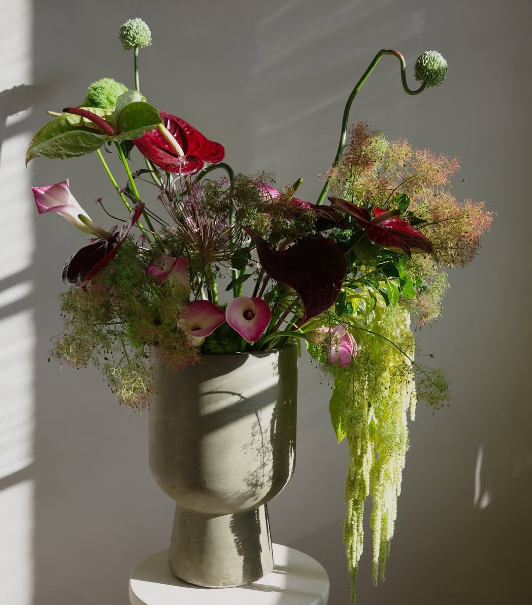 Flora & Friends Studio – Skulpturales florales Arrangement auf Beton-Podest von Kürsat Gürbüz