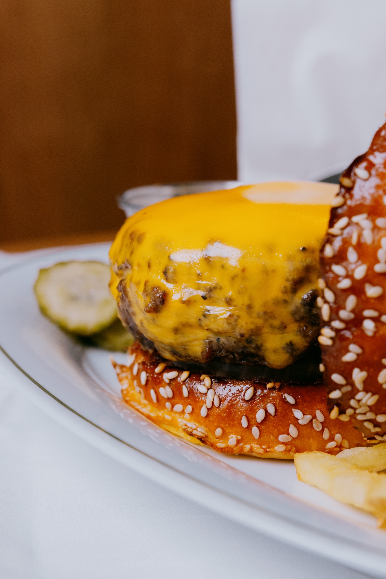 Goldies Bar – Hand serviert Tartar-Slider mit Kaviar und feinen Fries auf weißem Teller vor Holzvertäfelung von Kürsat Gürbüz
