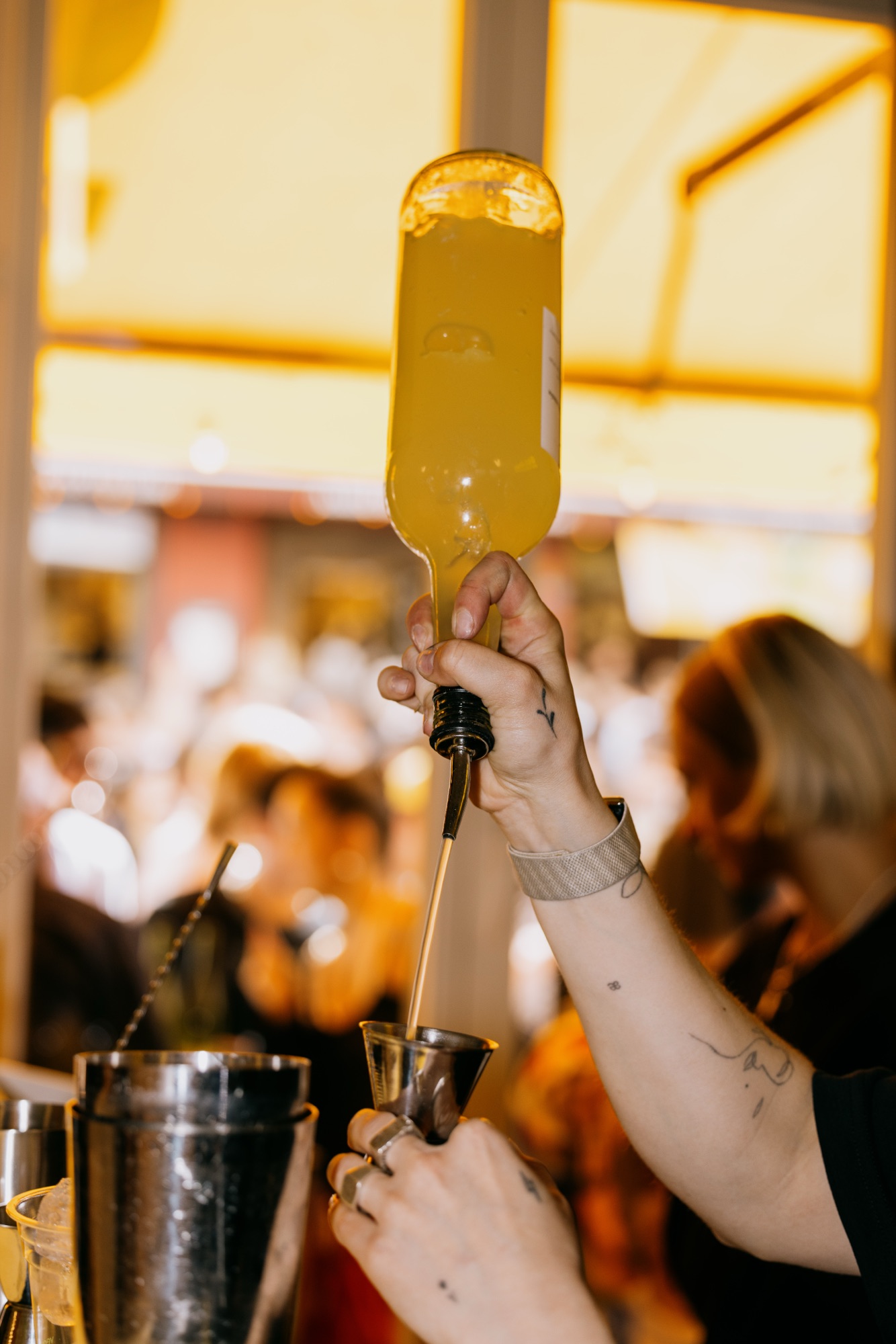 Goldies 1. Mai Fest – Barkeeper schenkt gelben Drink präzise in den Messbecher ein von Kürsat Gürbüz