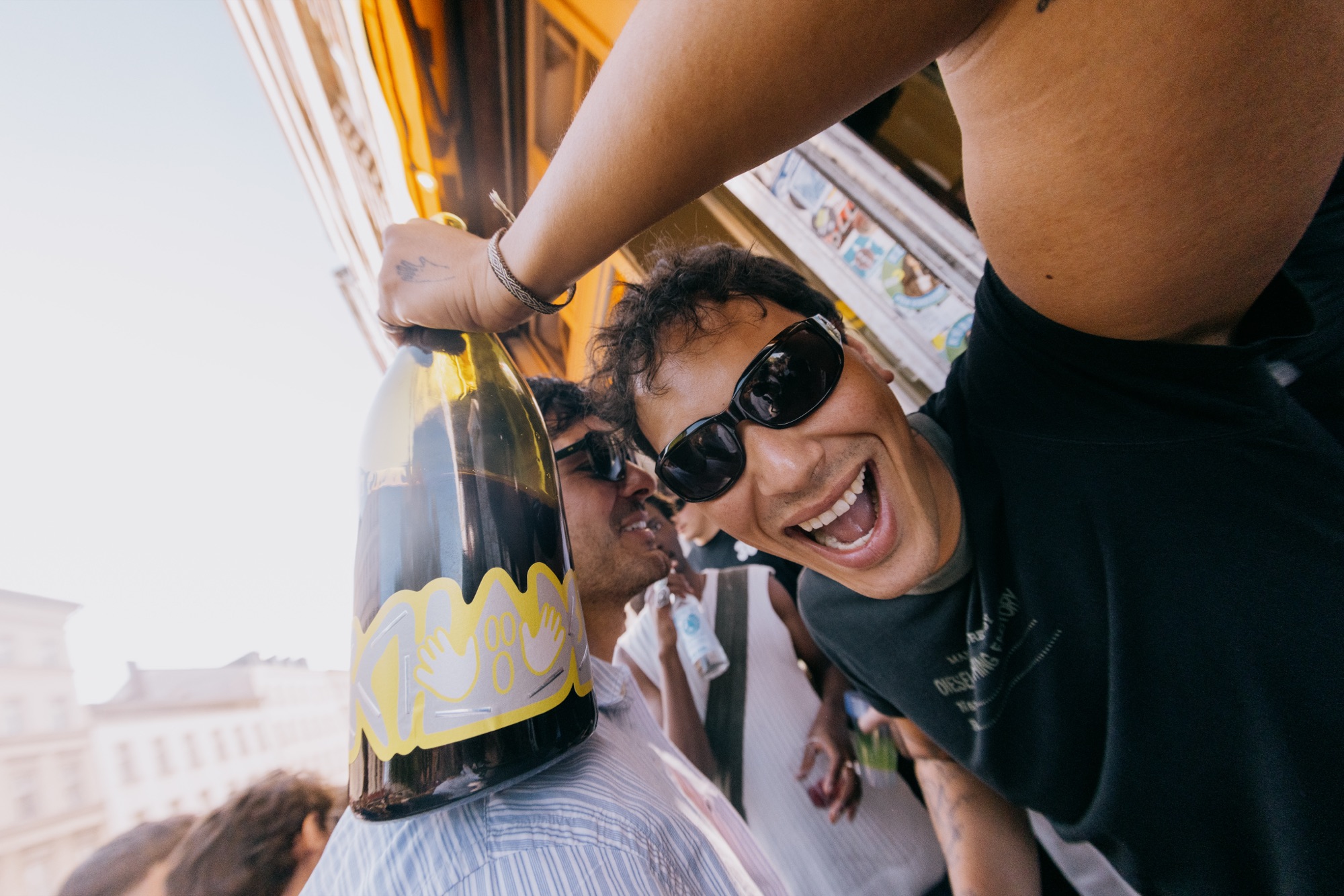 Goldies 1. Mai Fest – Partygast mit Sonnenbrille stemmt jubelnd eine Magnum-Weinflasche in die Höhe von Kürsat Gürbüz