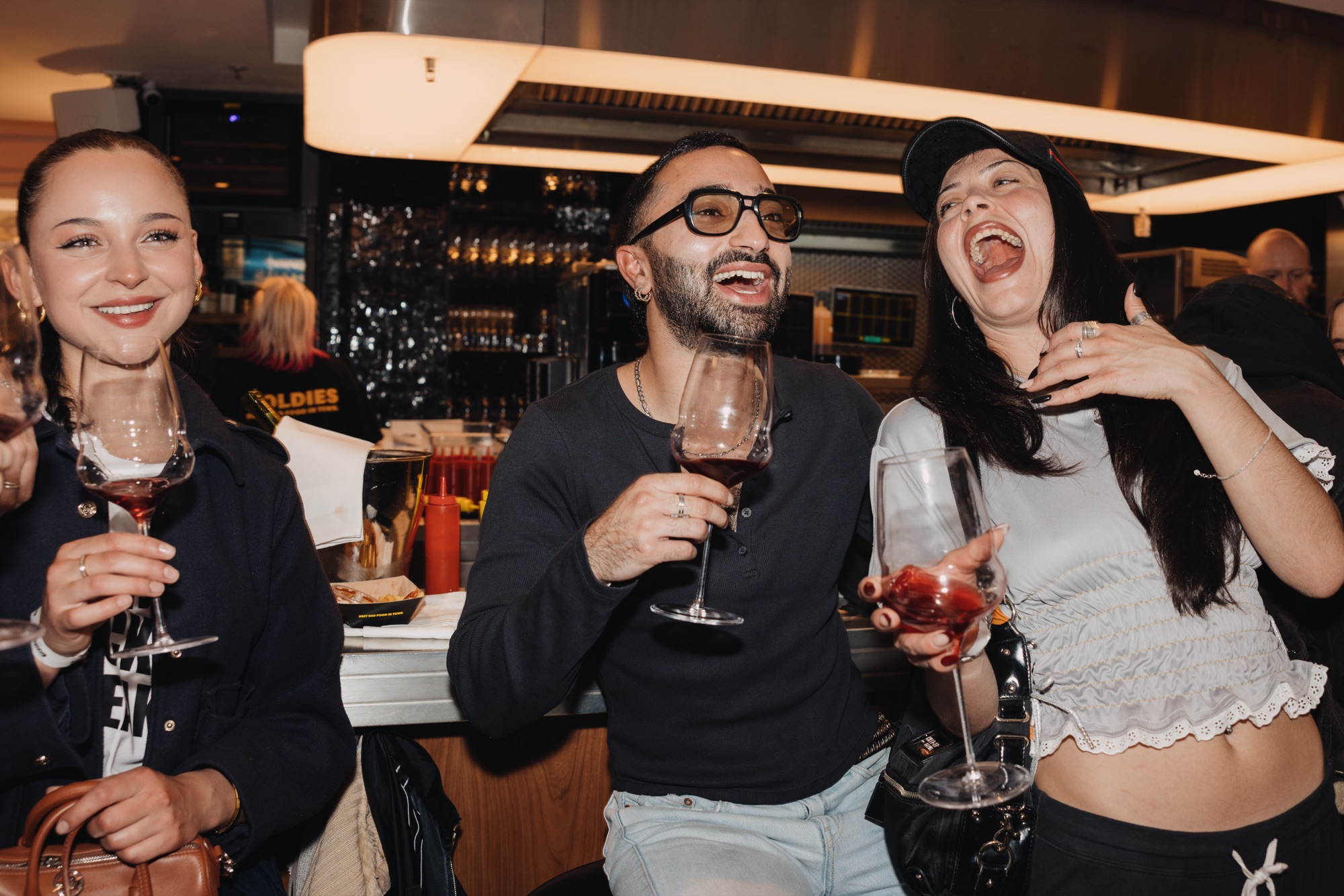 Goldies Bar × BHZ – Ausgelassen lachende Gäste stoßen an von Kürsat Gürbüz
