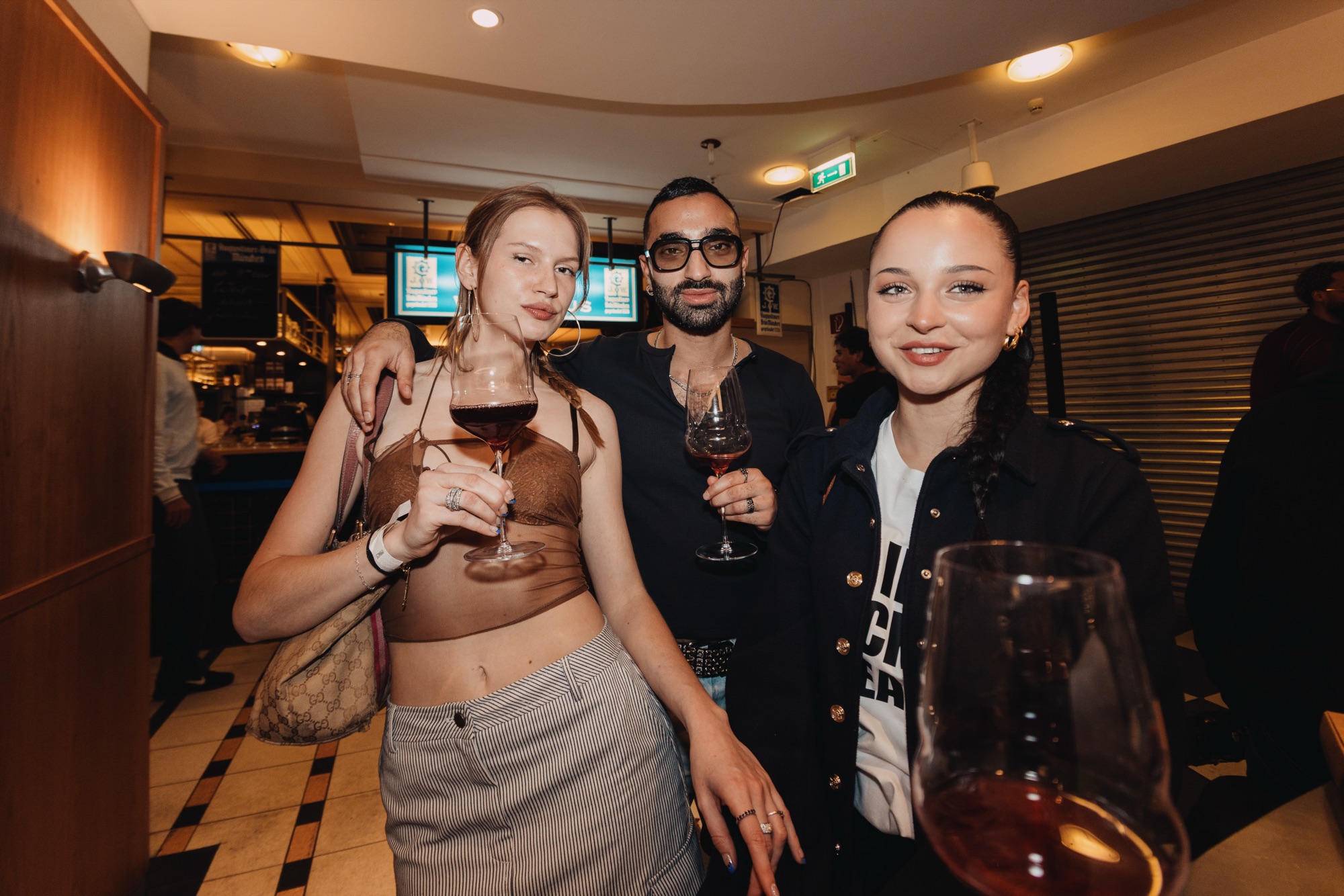 Goldies Bar × BHZ – Drei Gäste mit Weingläsern von Kürsat Gürbüz