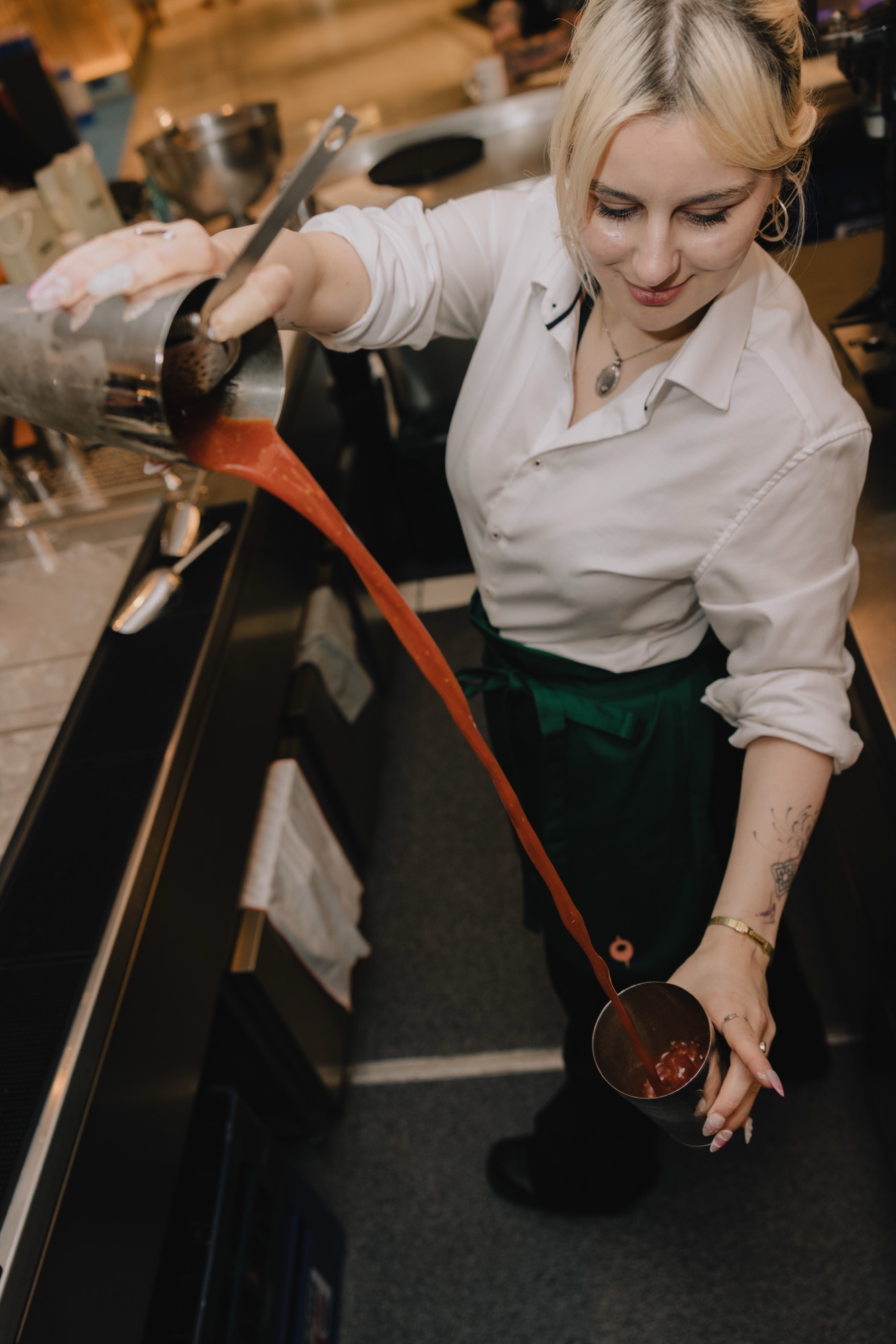Goldies Bar Breakfast Launch – Vogelperspektive auf Barkeeperin beim Cocktail-Pouring von Kürsat Gürbüz