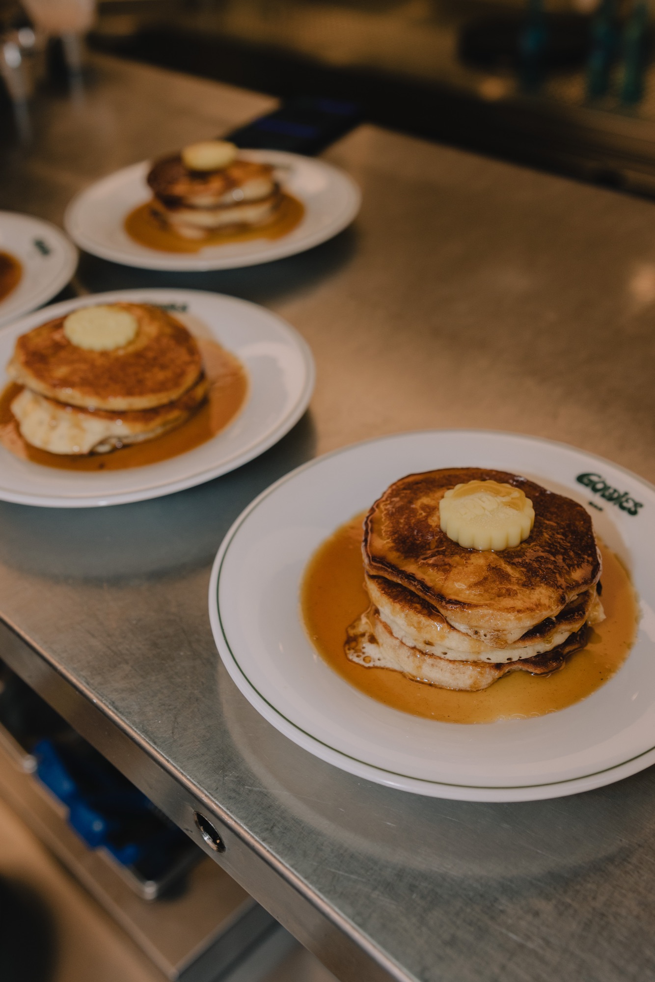 Goldies Bar Breakfast Launch – Pancakes mit Ahornsirup und zerlaufender Butter auf Tellern von Kürsat Gürbüz