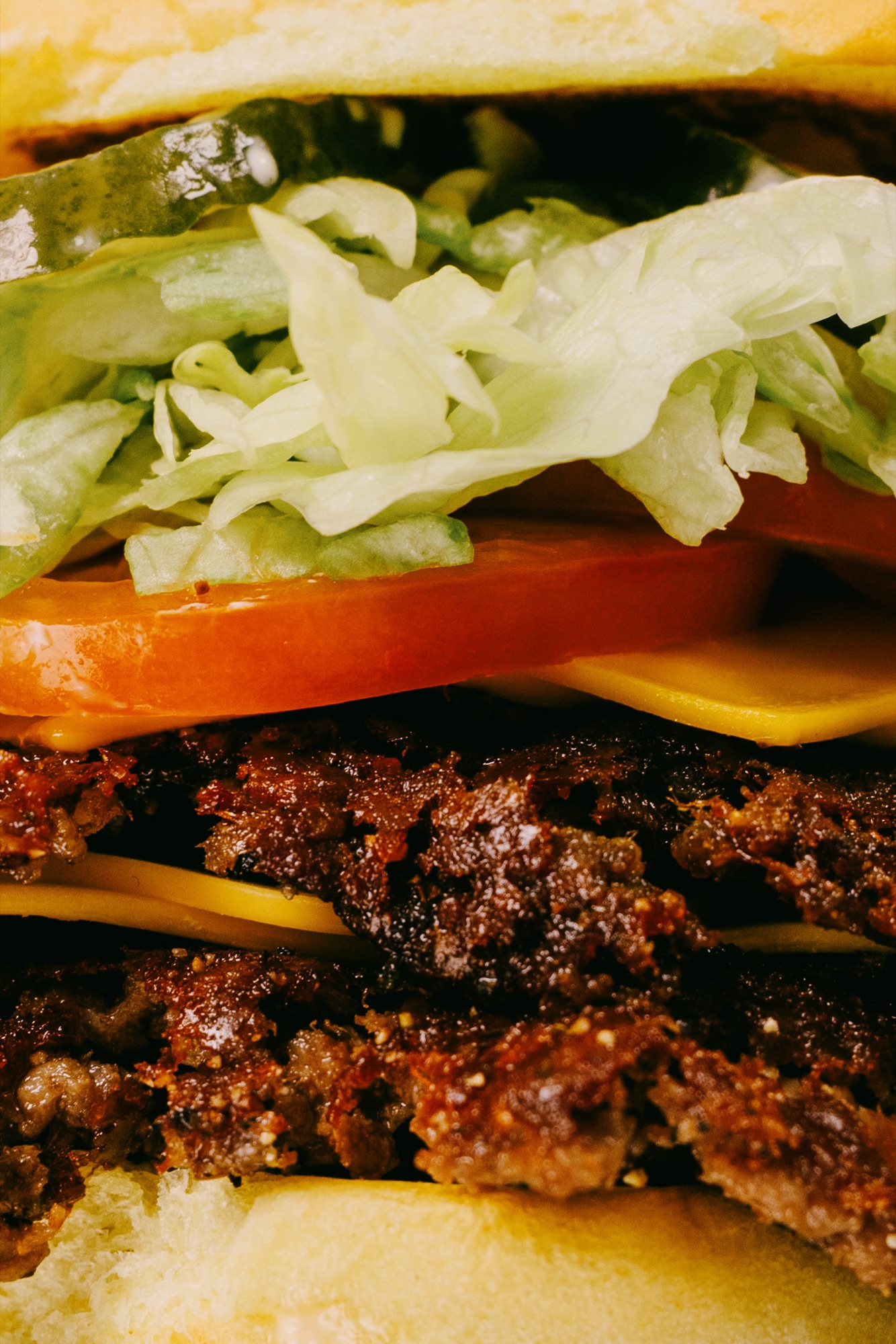 Goldies Smashburger – Makro-Detailaufnahme mit kross gebratenen Smash-Patties, geschmolzenem Cheddarkäse, frischer Tomate und knackigem Salat von Kürsat Gürbüz