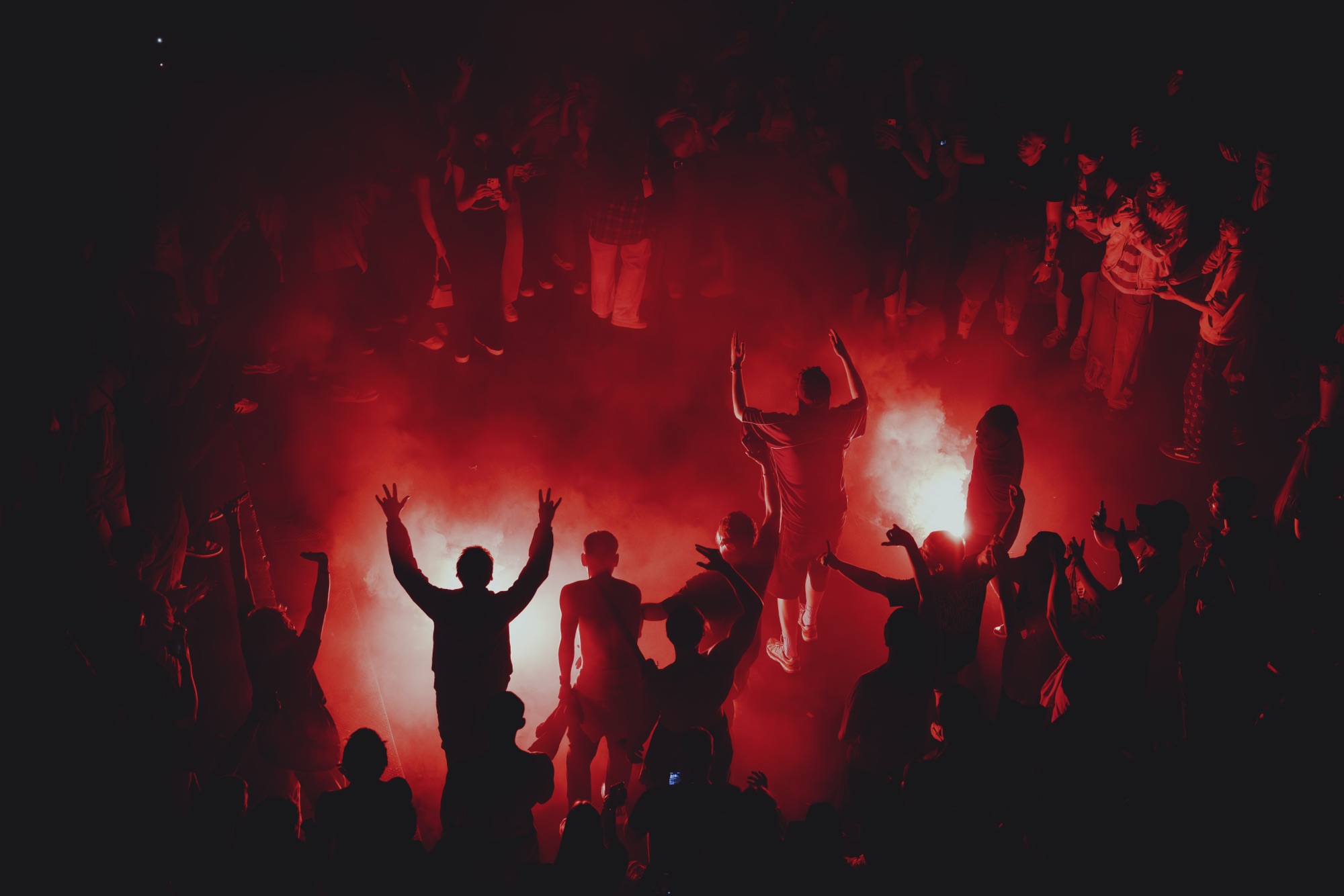 T-Fest Live – Moshpit-Kreis mit tanzenden Silhouetten im roten Schein von Kürsat Gürbüz