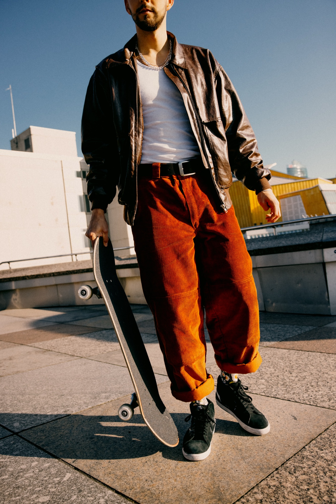 Wiggle Steps – Halbnah-Aufnahme Skater mit Skateboard und Lederjacke im Sonnenlicht von Kürsat Gürbüz