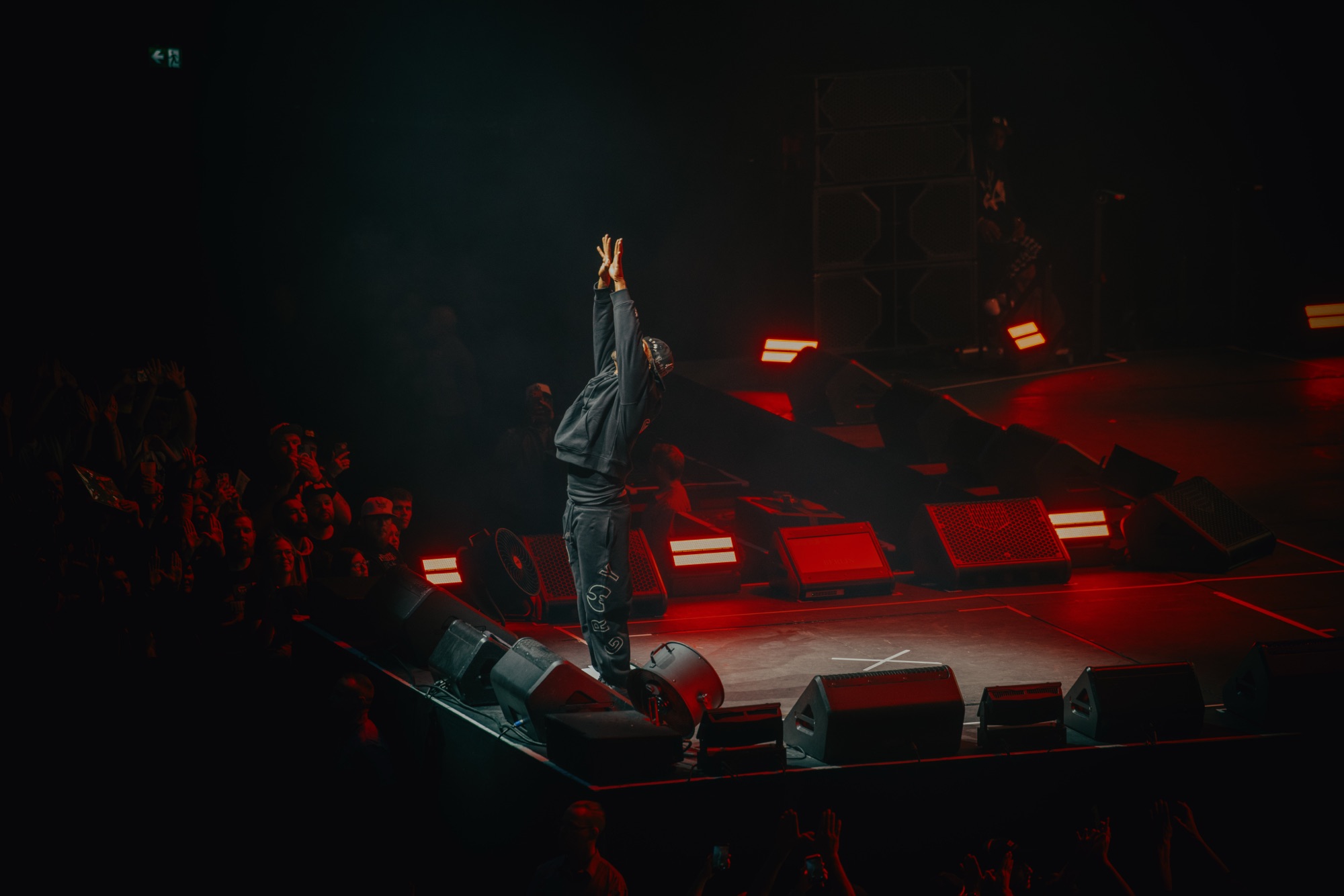 Wu-Tang Clan Live – Silhouette vor roten Bühnenmonitoren mit erhobenen Händen von Kürsat Gürbüz